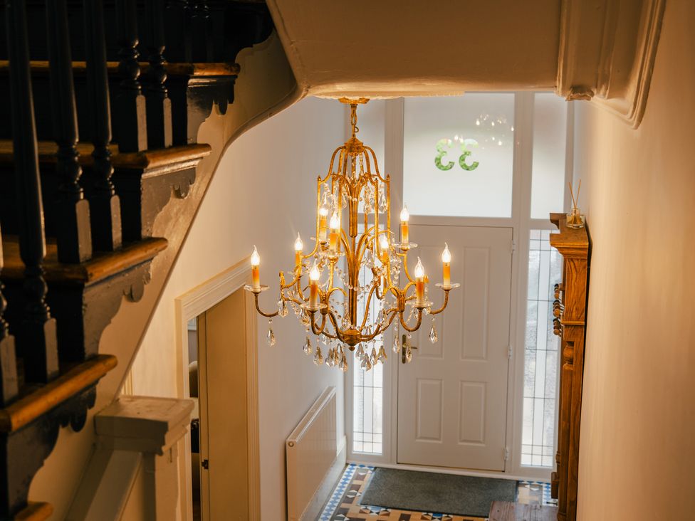 A hallway with a chandelier and staircase at 33 Lorne Street Chester