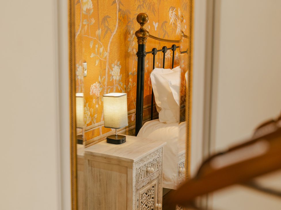 A bedroom with a bed and lamp seen in a mirror at 33 Lorne Street Chester