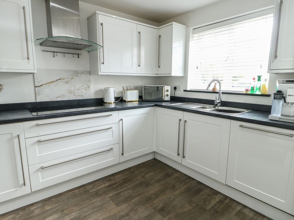 A kitchen featuring a sink and microwave at 9 Beckett Close, Colwyn Bay