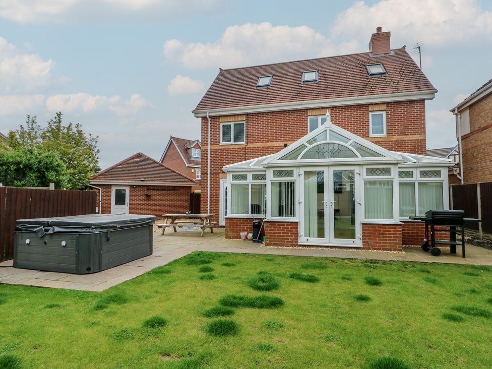 A garden with a hot tub, patio and seating at 9 Beckett Close in Colwyn Bay
