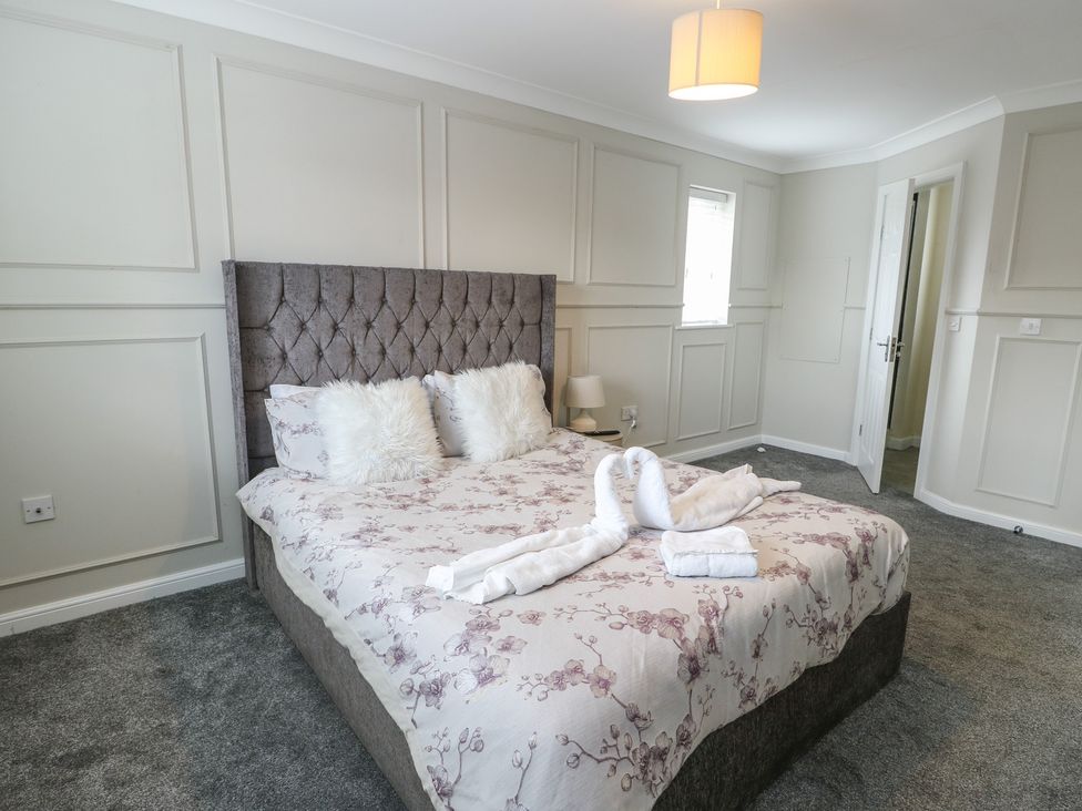 A bedroom with a bed and bedside lamp at 9 Beckett Close in Colwyn Bay