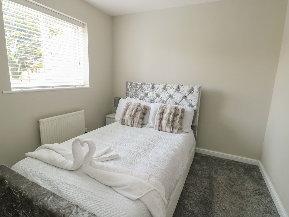 A bedroom with a bed and pillows at 9 Beckett Close in Colwyn Bay