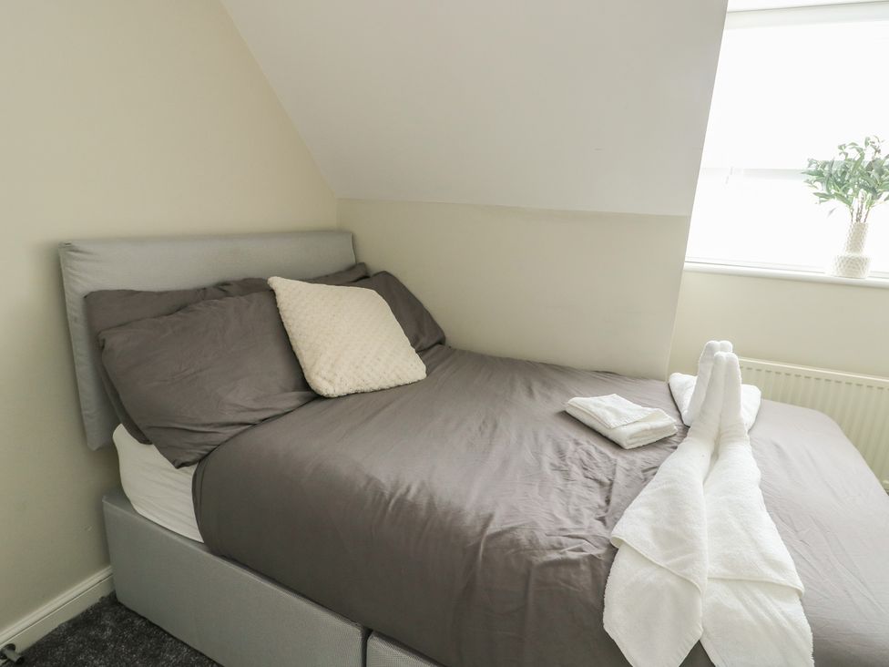 A bedroom with a bed and towels arranged at 9 Beckett Close Colwyn Bay