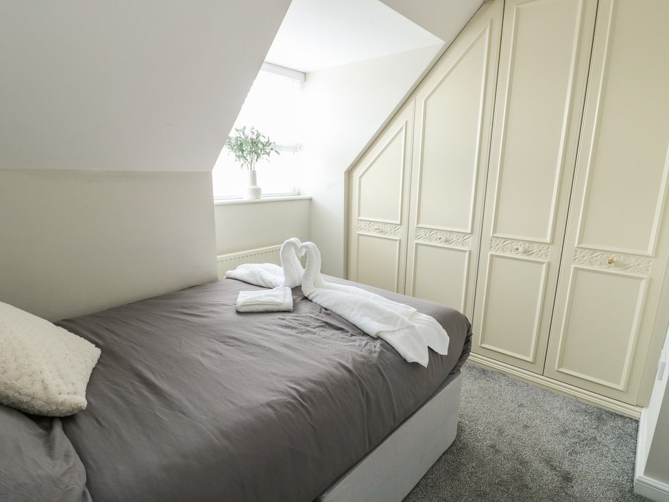 A bedroom with a bed and wardrobe at 9 Beckett Close in Colwyn Bay