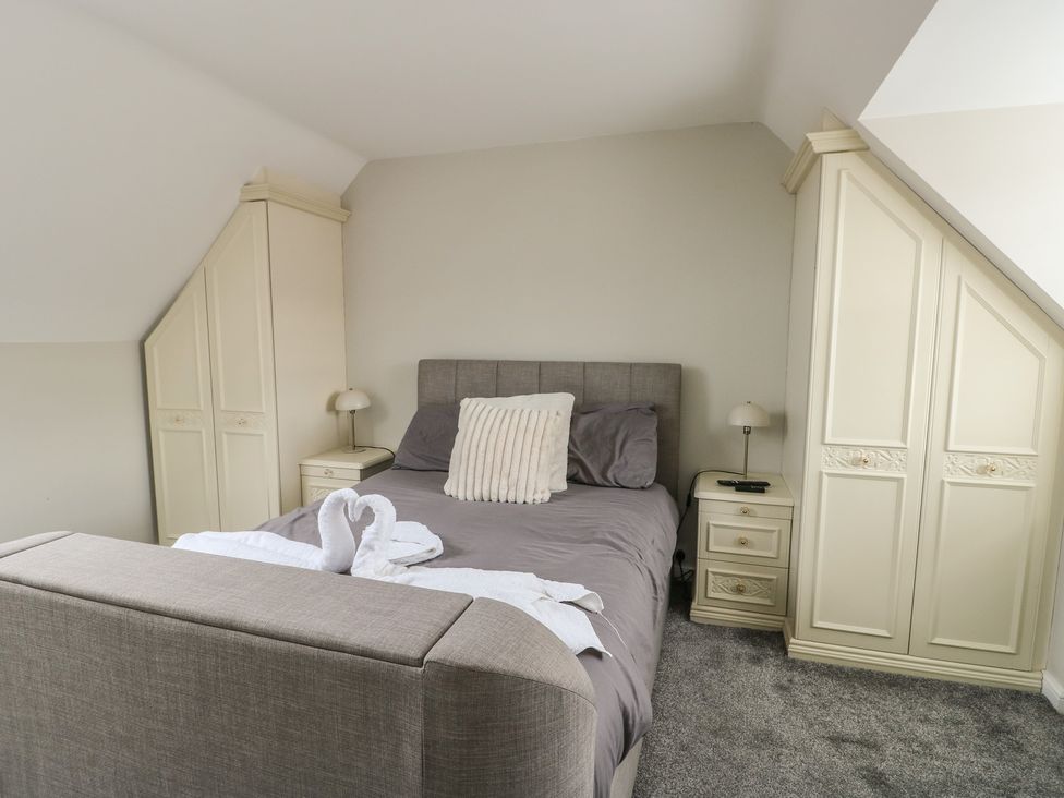 A bedroom with a bed and wardrobe at 9 Beckett Close in Colwyn Bay