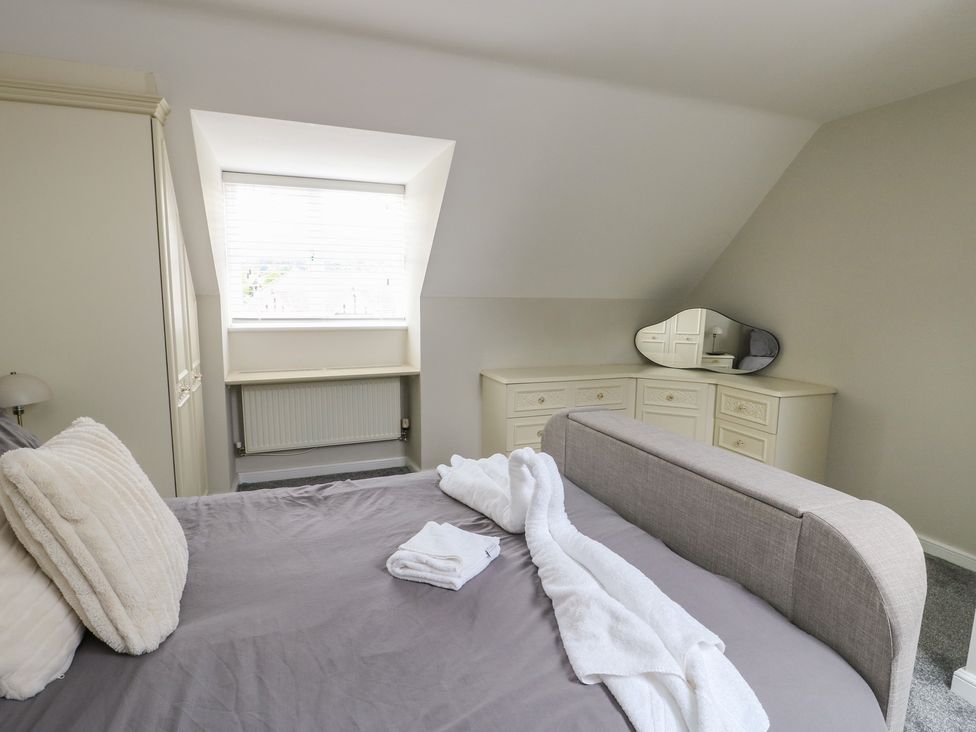 A bedroom with a bed and dresser at 9 Beckett Close in Colwyn Bay