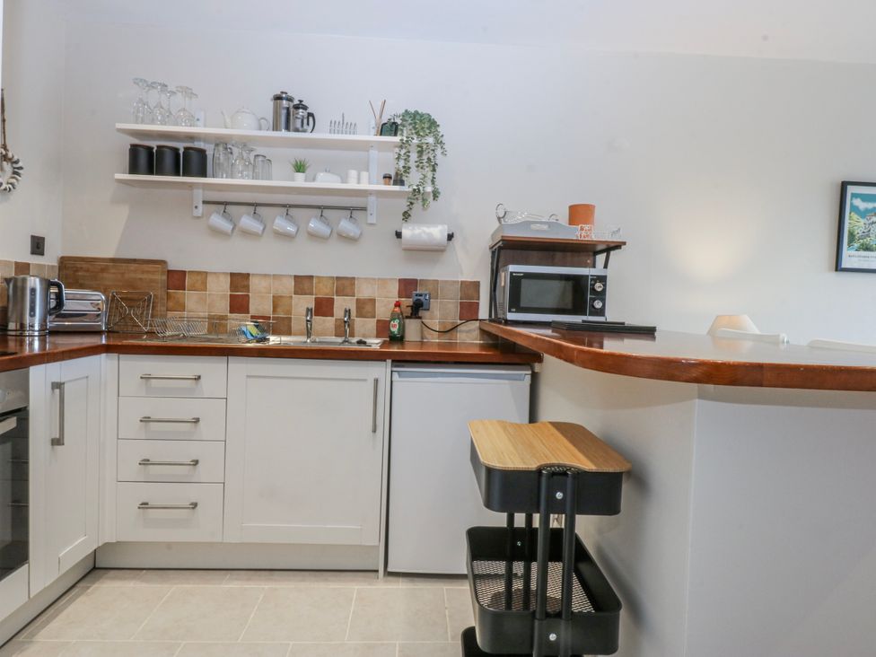 A kitchen with a sink and microwave at Oakley View Apartment in Porthmadog
