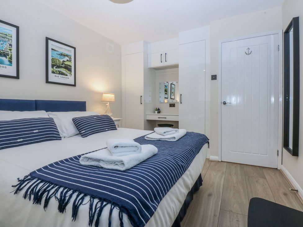A bedroom with a bed and wall art at Oakley View Apartment in Porthmadog
