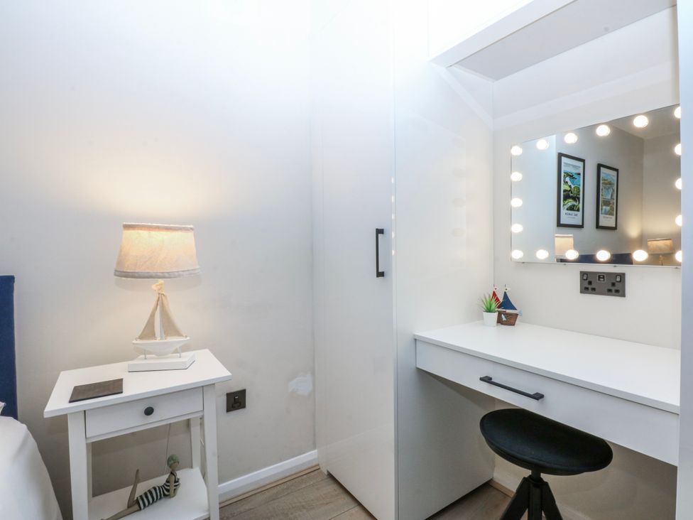 A bedroom with a vanity desk and lamp at Oakley View Apartment in Porthmadog