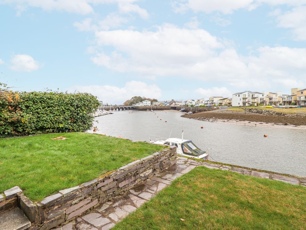 A view of the water with houses and a boat at Oakley View Apartment in Porthmadog