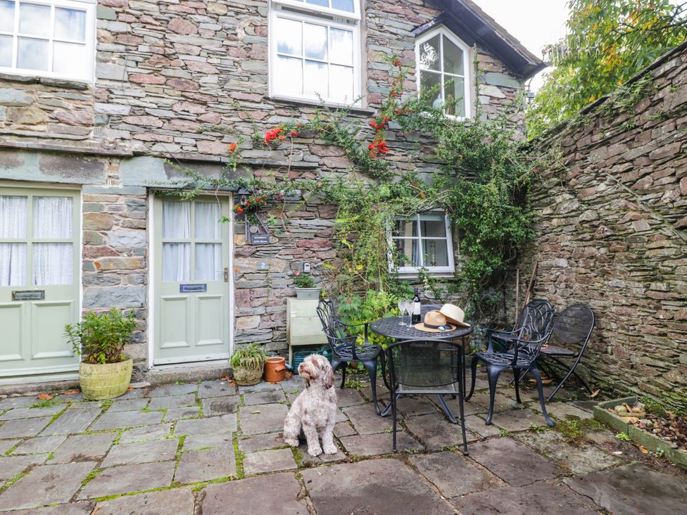 An outdoor seating area with a dog and table at 2 Bakers Yard
