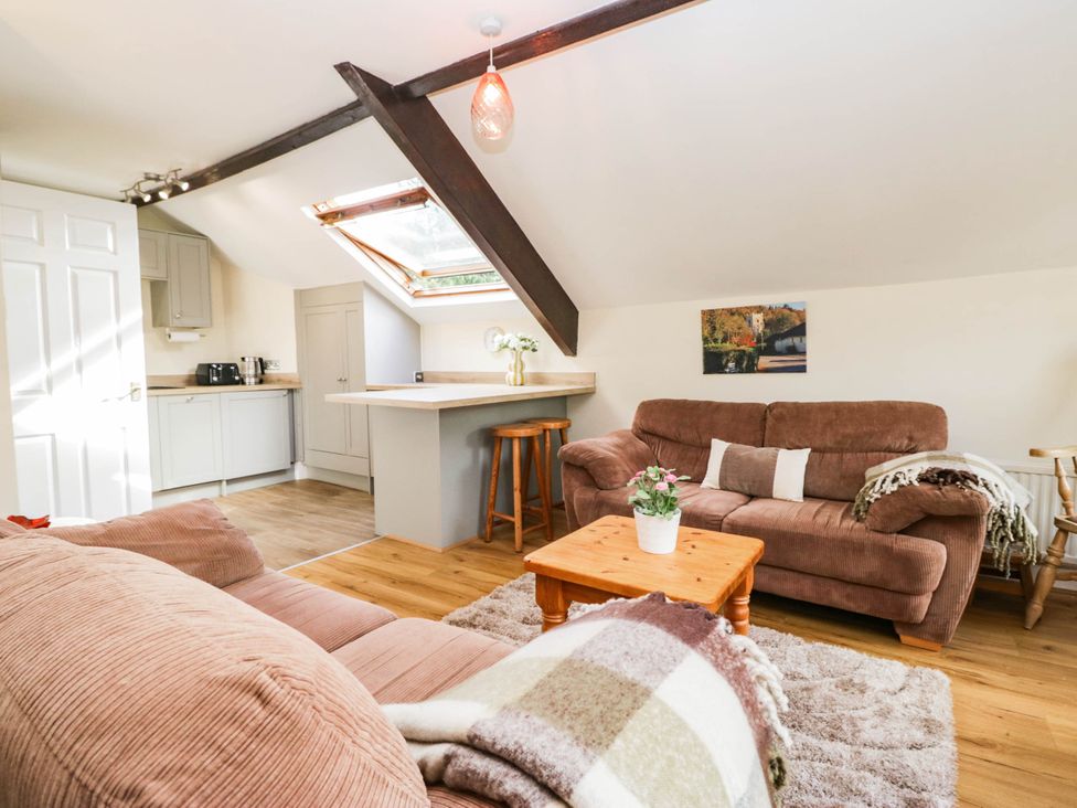 A living room with a skylight and kitchen at 2 Bakers Yard