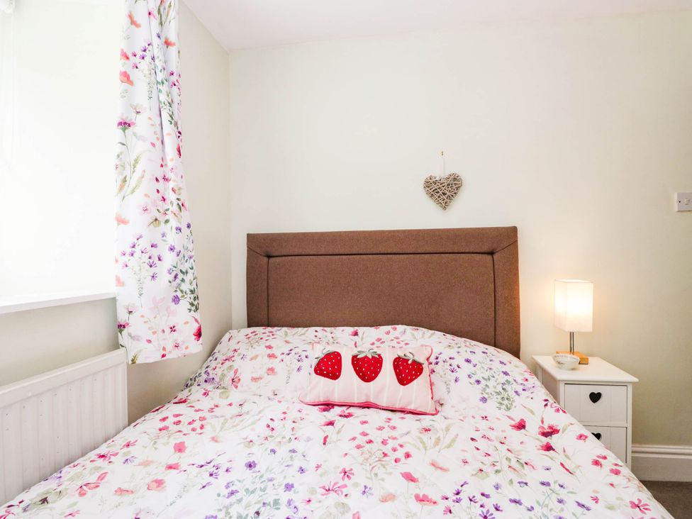 A bedroom with a bed and bedside table at 2 Bakers Yard