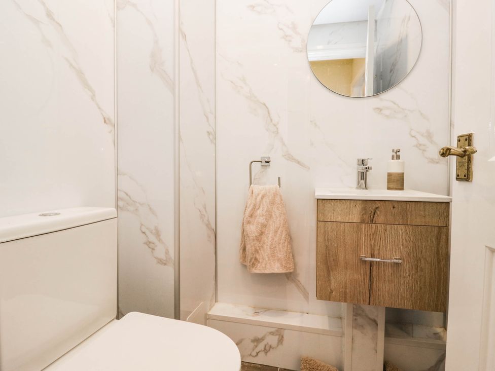 A bathroom with a toilet and sink at 2 Bakers Yard