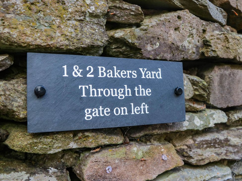 A sign indicating 1 & 2 Bakers Yard through the gate on left