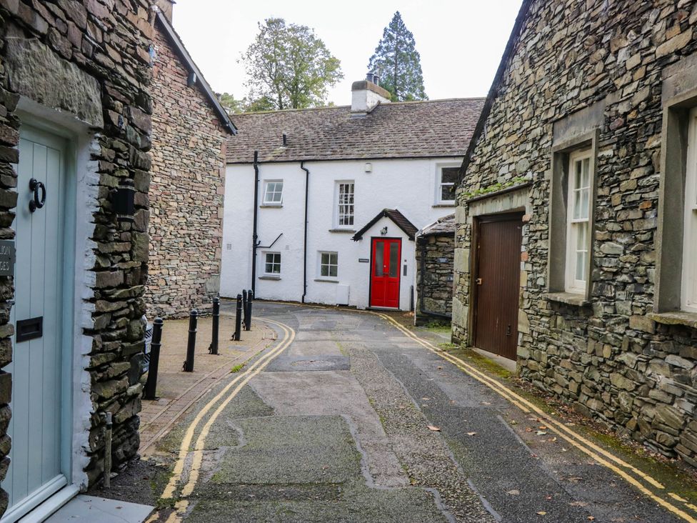 A street scene with stone houses and a red door at 2 Bakers Yard
