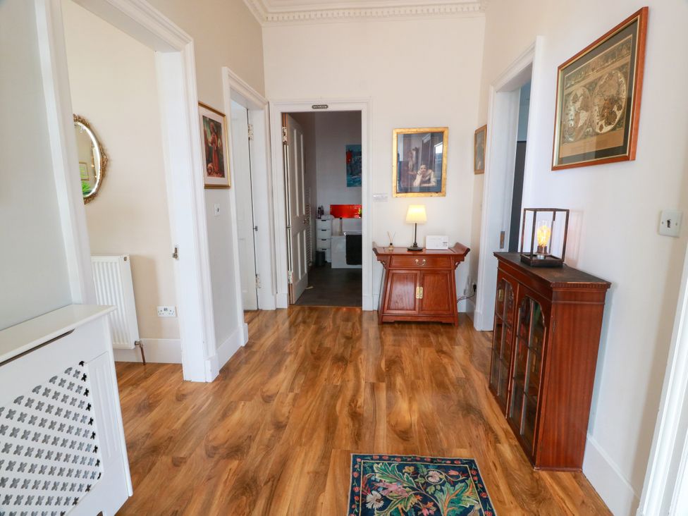 A hallway with a radiator, table and lamps at Ailsa View in Girvan