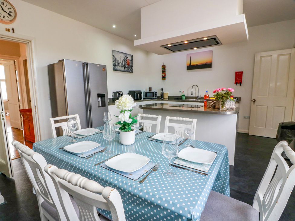 A kitchen with a dining table and appliances at Ailsa View in Girvan