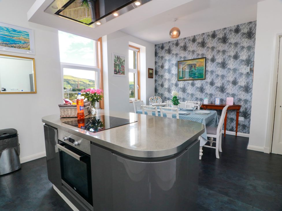 A kitchen with an island and dining area at Ailsa View in Girvan