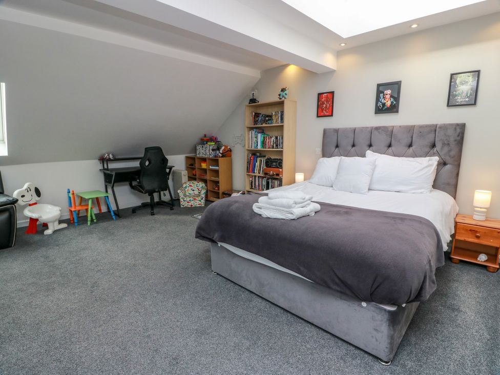 A bedroom with a bed, desk, and bookshelf at Ailsa View in Girvan