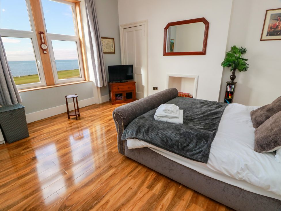 A bedroom with a bed and window view at Ailsa View in Girvan