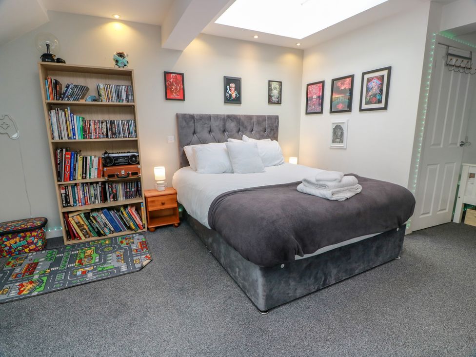 A bedroom with a bed and bookshelves at Ailsa View in Girvan