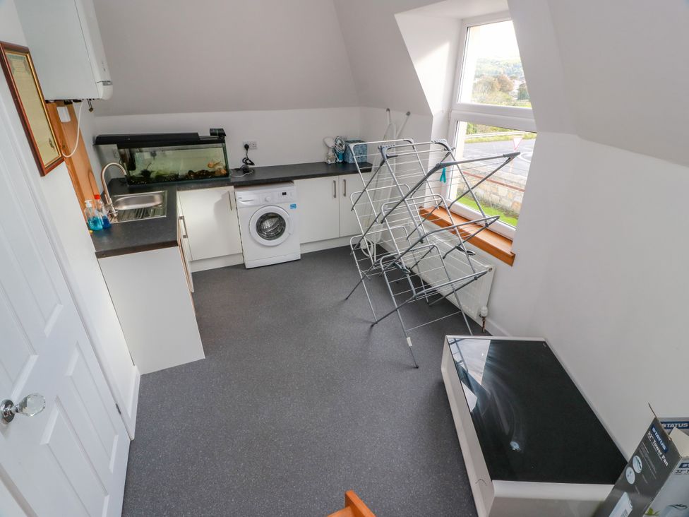 A laundry room with a washing machine and fish tank at Ailsa View in Girvan
