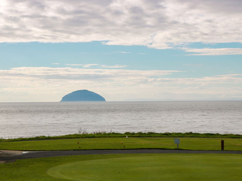 A view of an island in the ocean with grass in the foreground at Ailsa View in Girvan