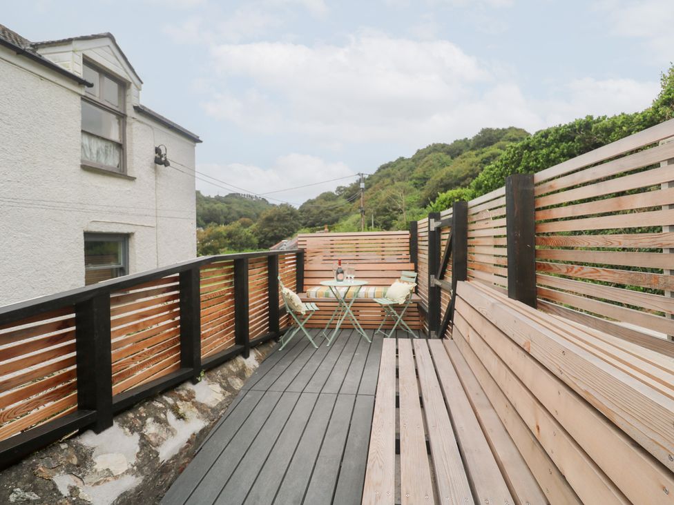 An outdoor area with a wooden deck and seating at Mavericks Wave in St Agnes