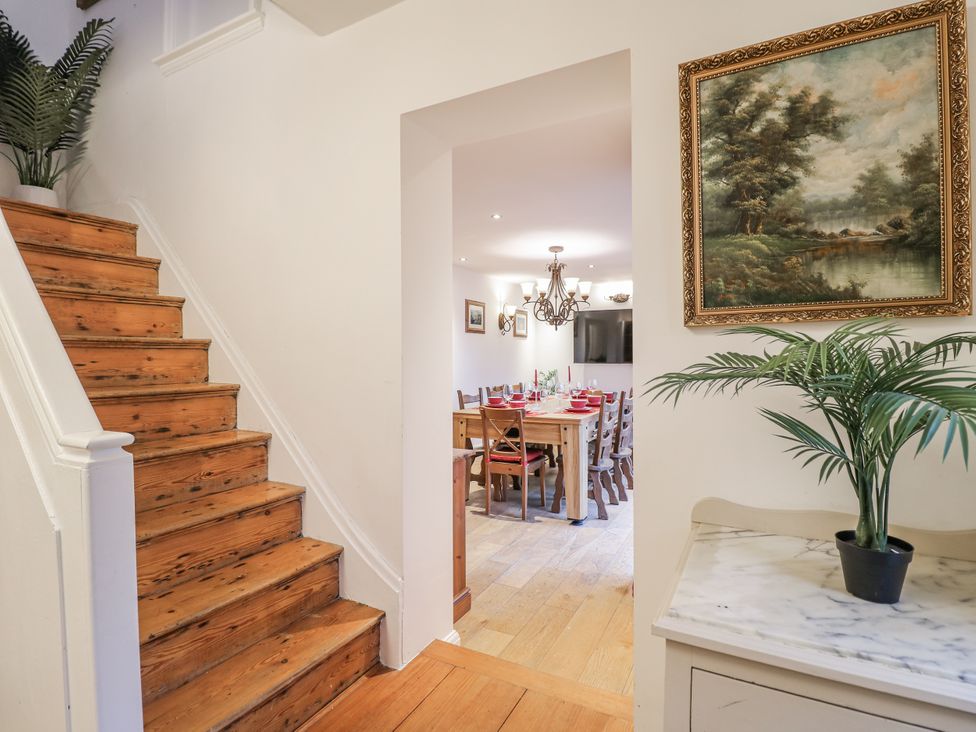 A dining room with stairs and a dining table at Mellbreak in Ashby-De-La-Zouch