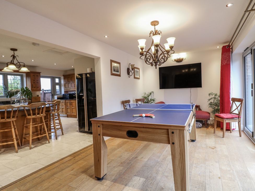 A dining room with a table tennis table and a chandelier at Mellbreak in Ashby-De-La-Zouch