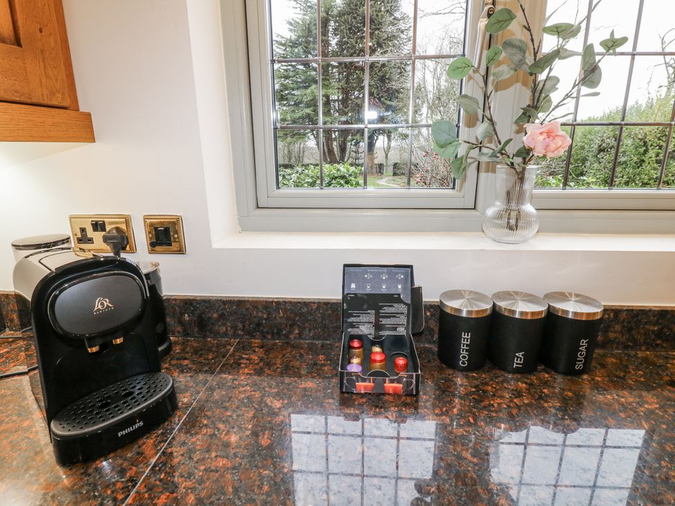 A kitchen with a coffee machine and storage containers at Mellbreak in Ashby-De-La-Zouch