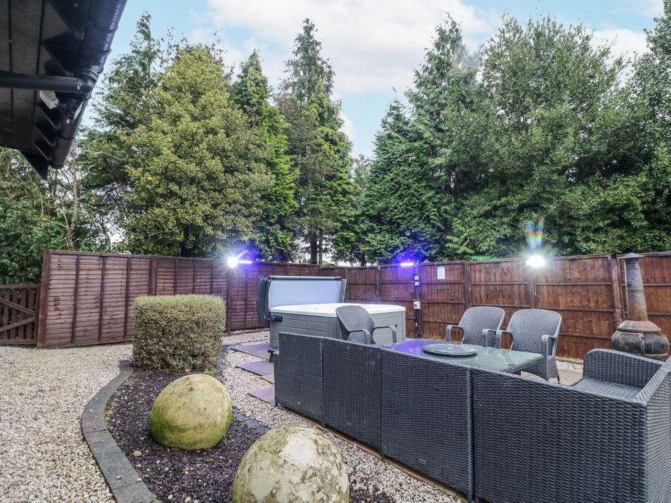 A garden with a hot tub and patio furniture at Mellbreak Ashby-De-La-Zouch