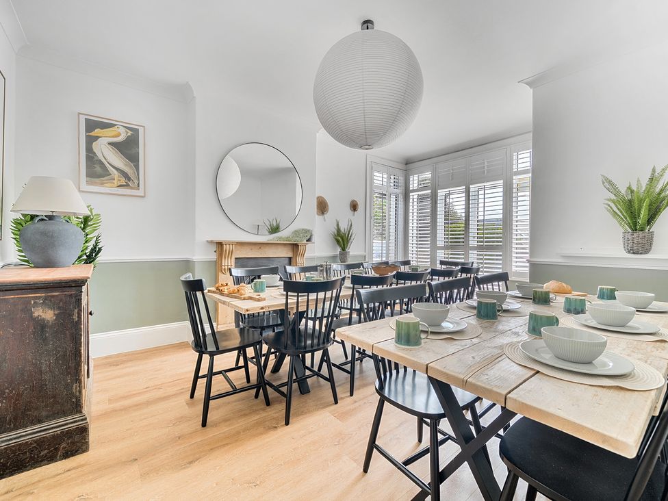 A dining room with a table set for meals at Palm House in Newquay