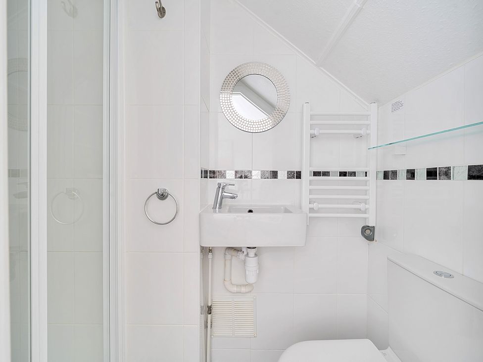 A bathroom with a shower, sink, and toilet at Palm House in Newquay