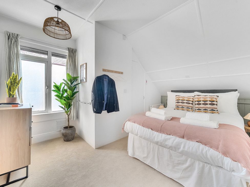 A bedroom with a bed and plant at Palm House in Newquay