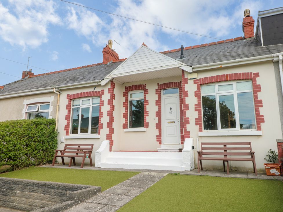 A house with windows and benches in front at The Bungalow in Porthcawl