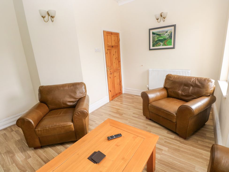 A sitting room with two armchairs and a coffee table at The Bungalow in Porthcawl