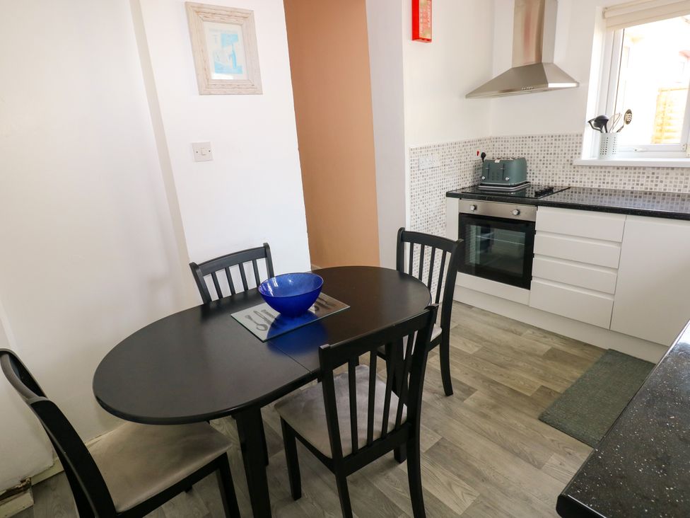 A kitchen with a dining table and chairs at The Bungalow in Porthcawl