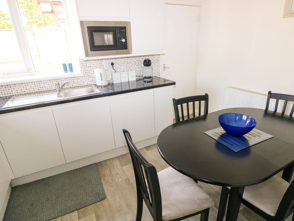 A kitchen with a table and chairs at The Bungalow in Porthcawl