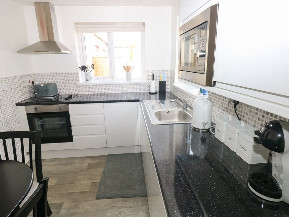 A kitchen with appliances and utensils at The Bungalow in Porthcawl