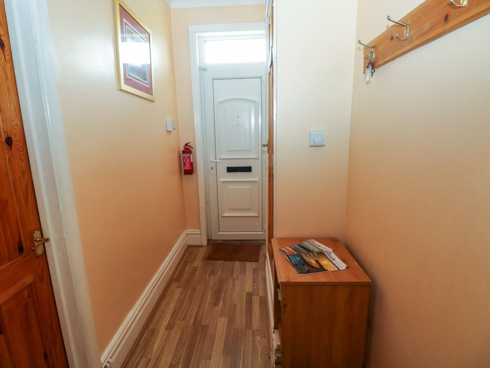 A hallway with a front door and a coat rack at The Bungalow in Porthcawl
