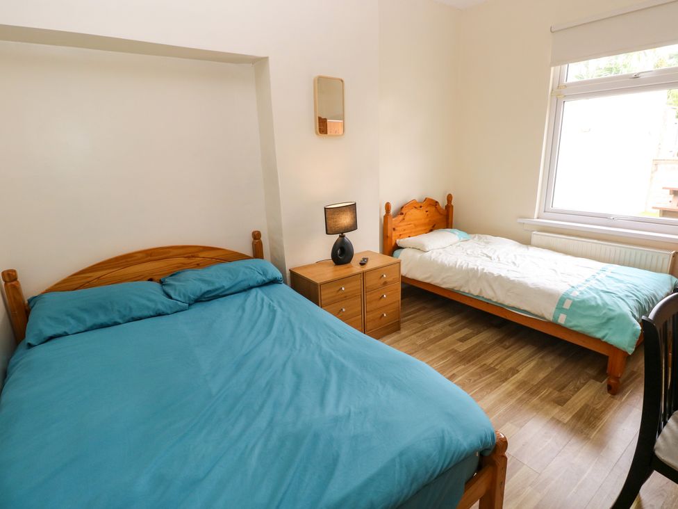 A bedroom with a double bed and a single bed at The Bungalow in Porthcawl
