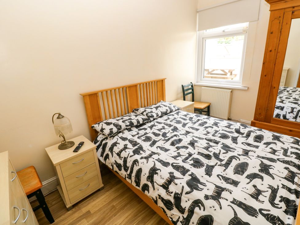A bedroom with a bed and bedside table at The Bungalow in Porthcawl