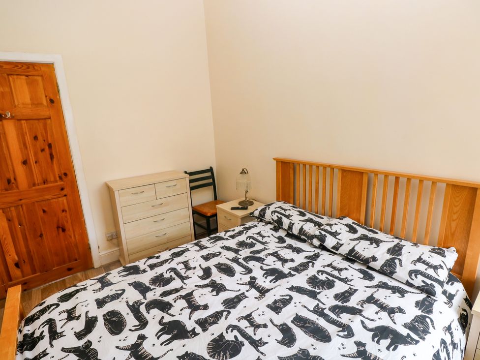 A bedroom with a bed and dresser at The Bungalow in Porthcawl