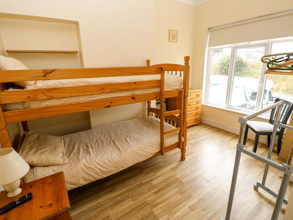 A bedroom with a bunk bed and a window at The Bungalow in Porthcawl
