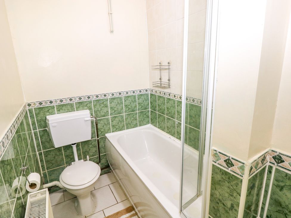 A bathroom with a bathtub and shower at The Bungalow in Porthcawl