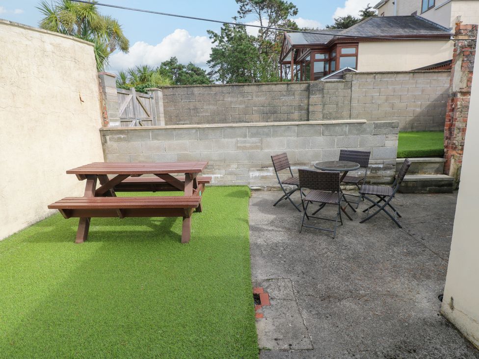 A garden with a picnic table and outdoor chairs at The Bungalow in Porthcawl