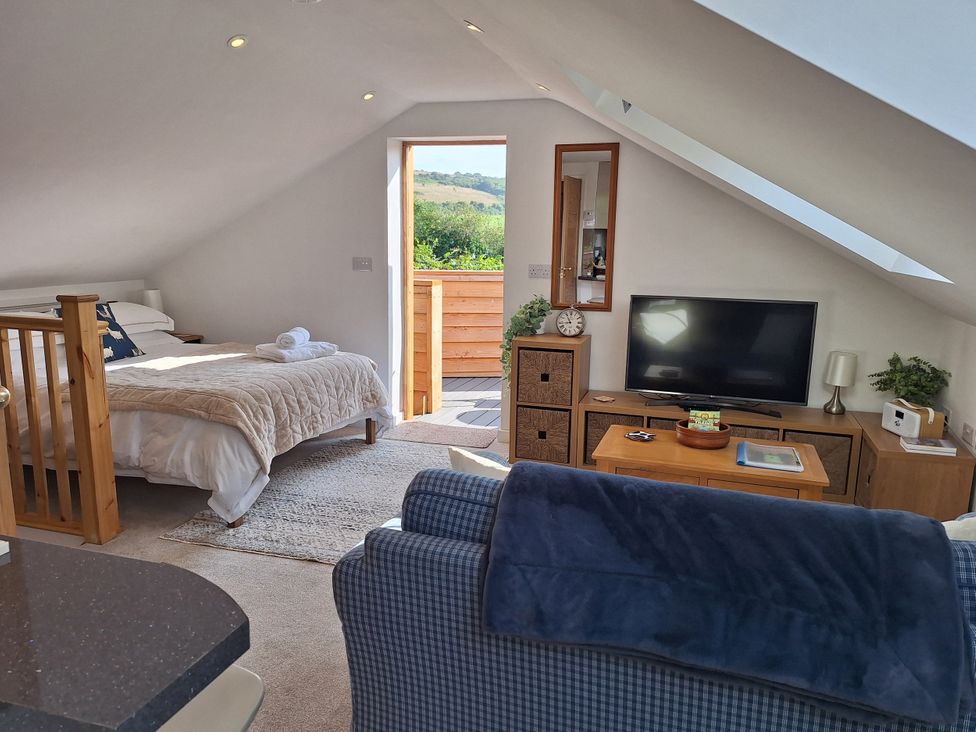 A bedroom with a bed and television at The Halt in Maiden Newton