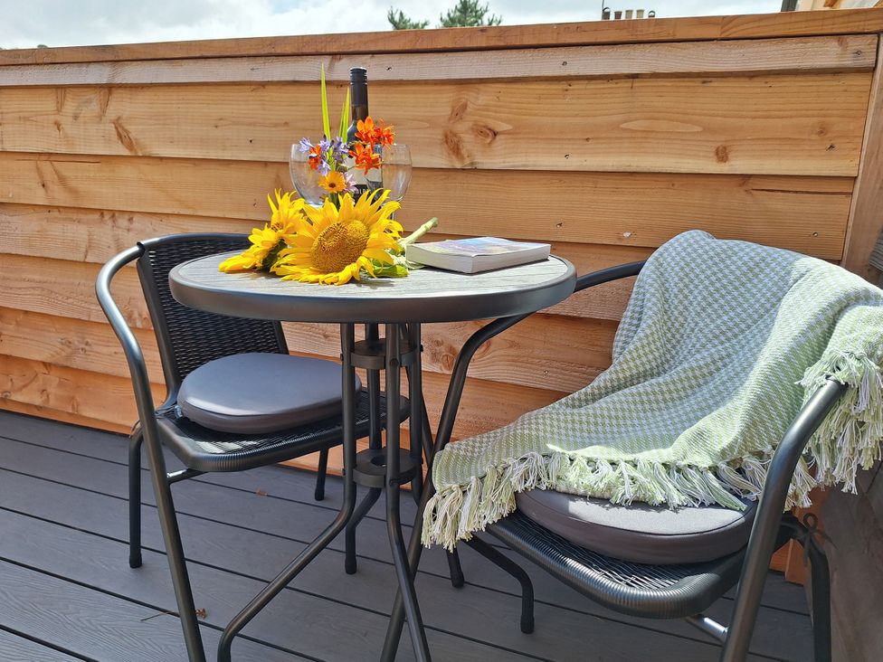 A table with sunflowers and a book on an outdoor patio at The Halt in Maiden Newton
